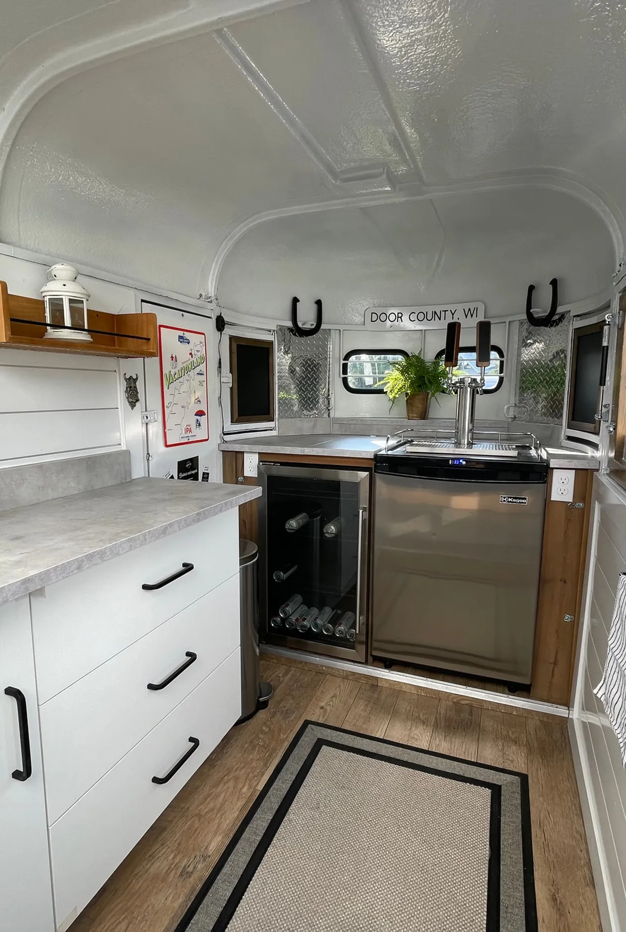 Interior of the Door County Mobile Bar renovated horse trailer showing the tap and ice bin setup